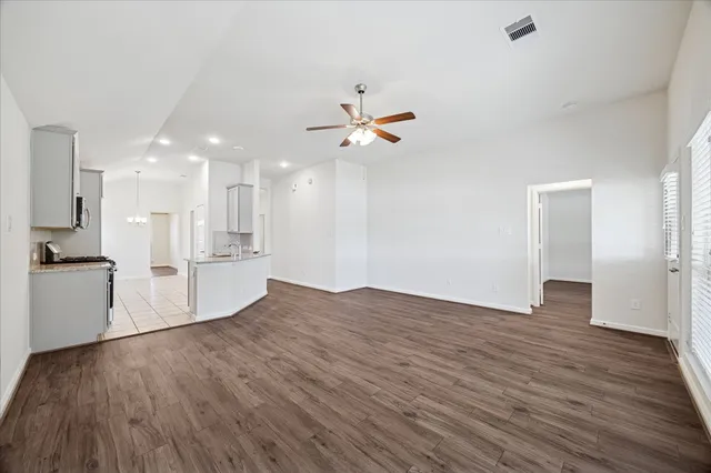 a view of a kitchen with wooden floor and a ceiling fan