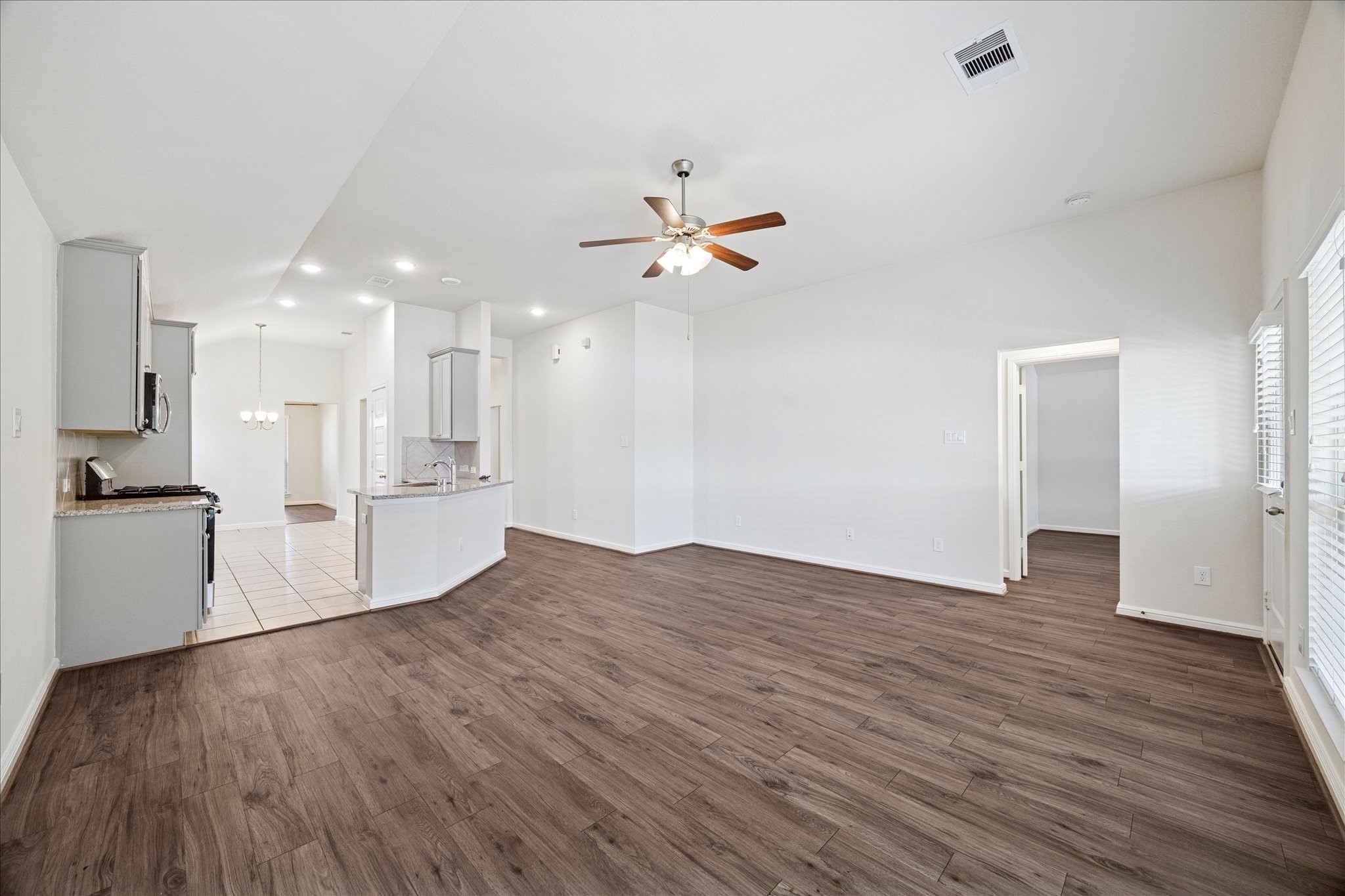 18203 Alora Springs Trace Cypress, TX 77433 - Photo 13 of 30 a view of a kitchen with wooden floor and a ceiling fan
