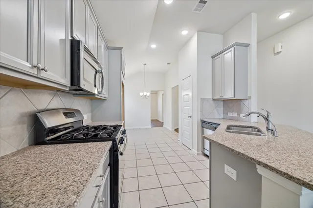 a kitchen with stainless steel appliances granite countertop a sink stove and cabinets