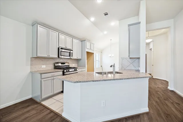 a kitchen with stainless steel appliances granite countertop a sink stove and refrigerator