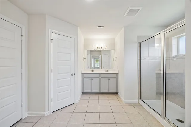 a bathroom with a shower a sink and a mirror