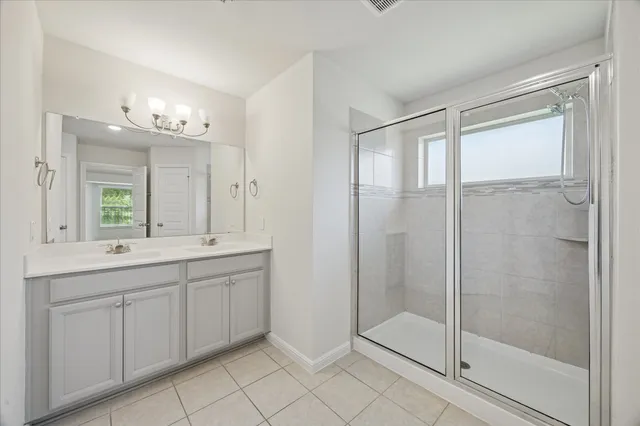 a bathroom with a double vanity sink and a shower