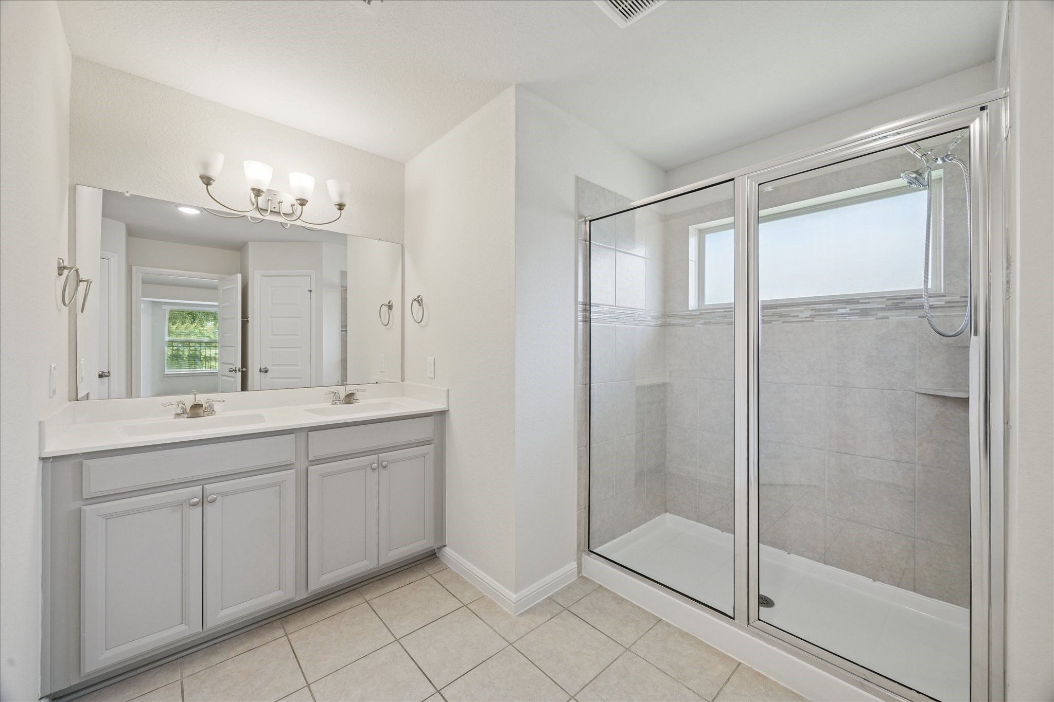 18203 Alora Springs Trace Cypress, TX 77433 - Photo 21 of 30 a bathroom with a double vanity sink and a shower