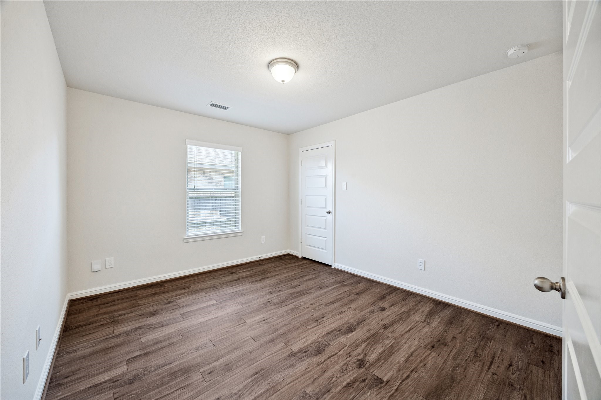 18203 Alora Springs Trace Cypress, TX 77433 - Photo 26 of 30 an empty room with wooden floor and windows