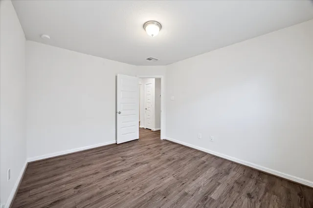 a view of an empty room with wooden floor