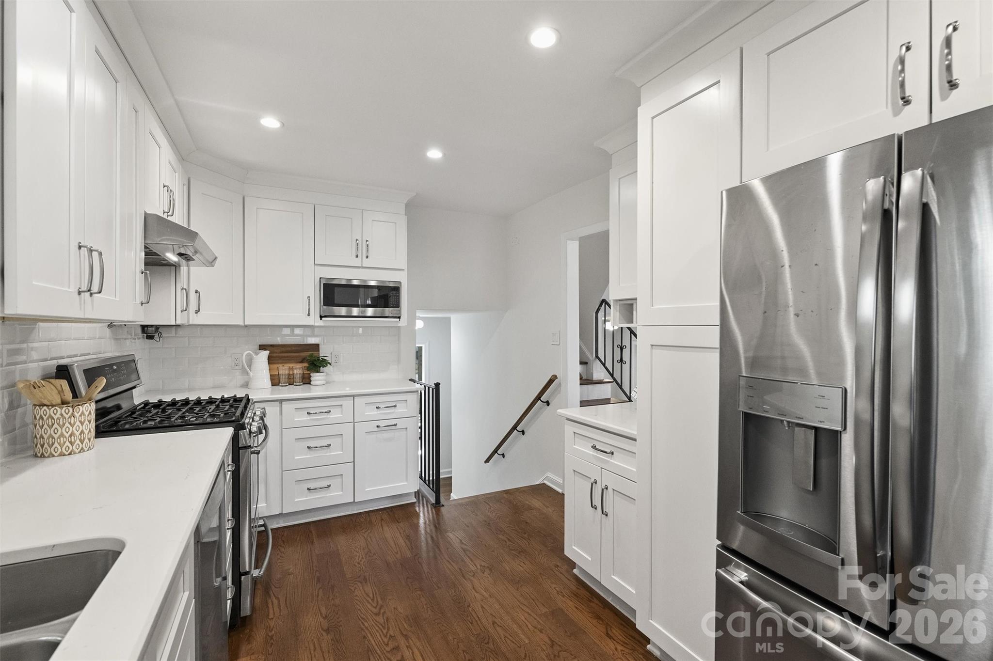 3808 Flowerfield Road Charlotte, NC 28210 - Photo 25 of 48 a kitchen with white cabinets and stainless steel appliances