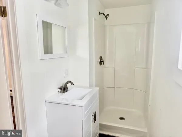 a bathroom with a shower a sink and a mirror