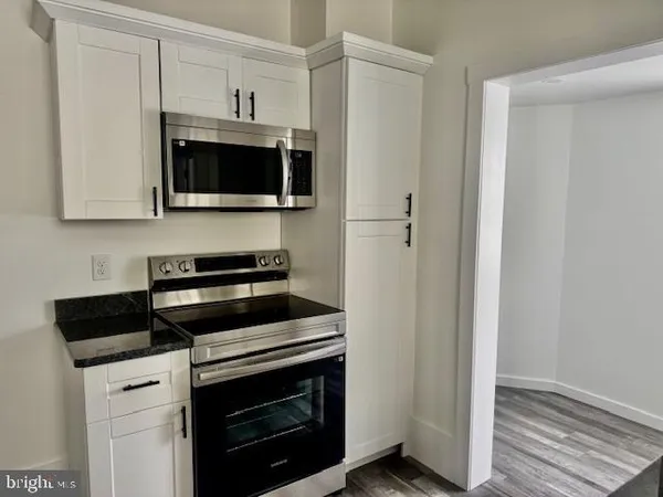 a kitchen with stainless steel appliances a stove microwave and refrigerator