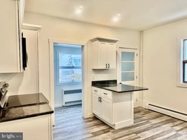 a kitchen with granite countertop a sink and a stove top oven