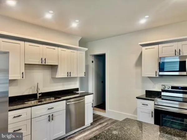 a kitchen with stainless steel appliances granite countertop a sink stove and cabinets