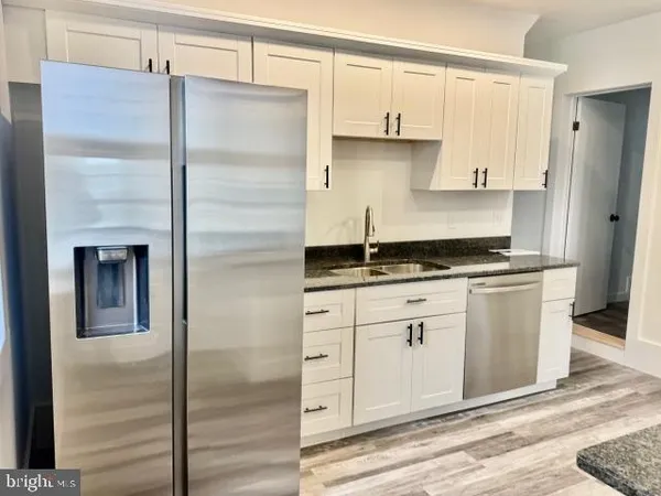 a kitchen with white cabinets and black appliances