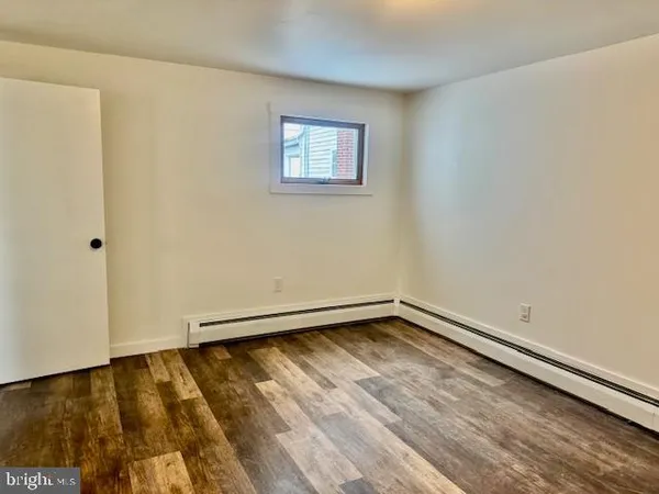 a view of a room with wooden floor and a window