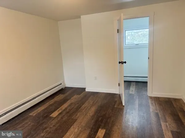 an empty room with wooden floor and closet