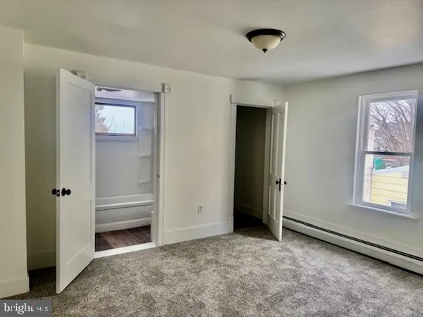 an empty room with windows and closet