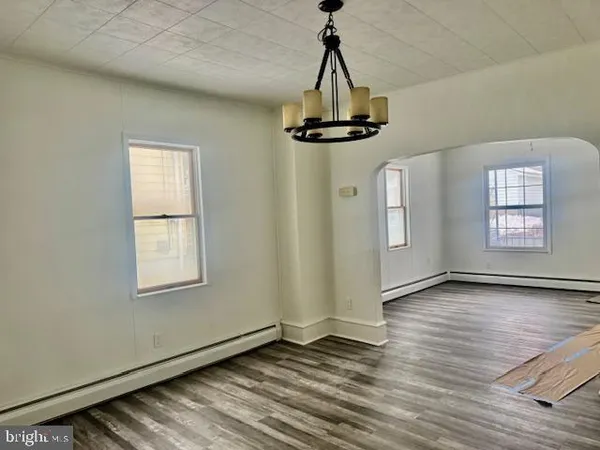 a view of empty room with wooden floor and window