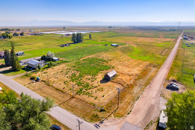 161 South 2nd Street East Paris, ID 83261 - Photo 2 of 28 Expansive land parcel with surrounding agricultural fields, distant mountains, and a visible barn structure