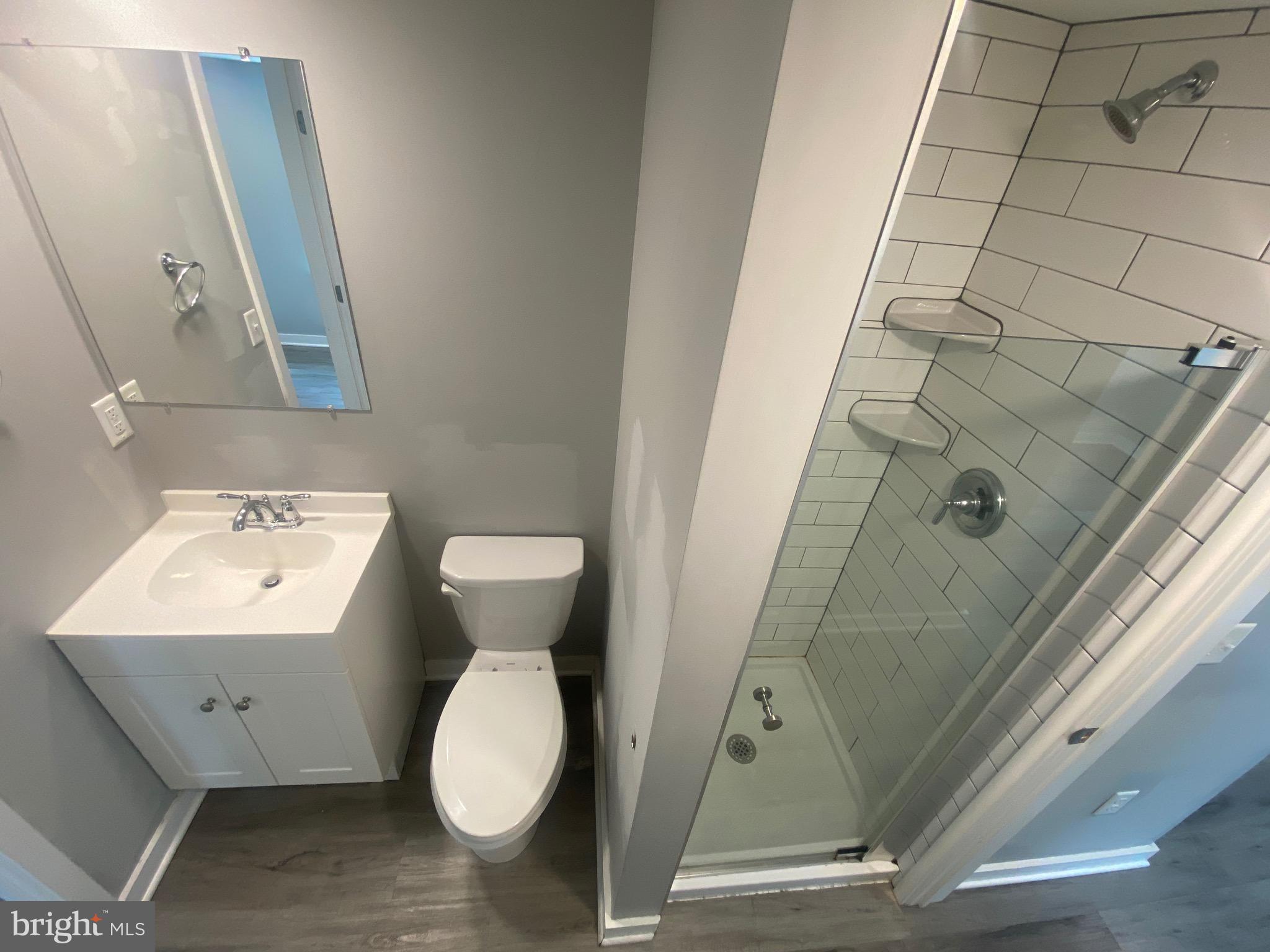 218 West King Street, Unit 3 Lancaster, PA 17603 - Photo 6 of 8 a bathroom with a toilet sink and mirror
