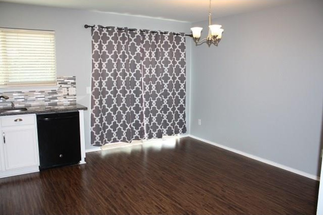 1120 Apollo Circle Round Rock, TX 78664 - Photo 9 of 14 Spacious room featuring dark wood-finish flooring, light gray walls, and a modern ceiling light fixture