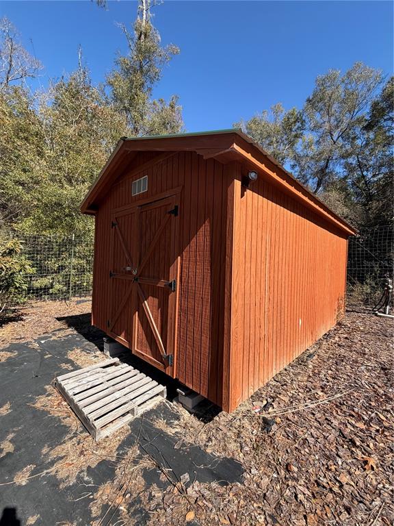 a view of a backyard with wooden fence and plants