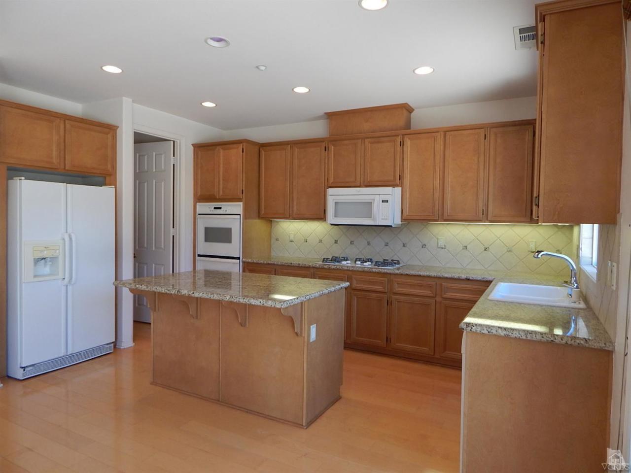 1402 Hidden Ranch Drive Simi Valley, CA 93063 - Photo 7 of 14 a kitchen with kitchen island granite countertop a sink a stove and a refrigerator