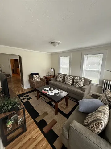 a living room with furniture and wooden floor