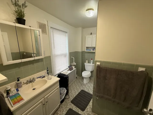 a bathroom with a sink mirror and toilet