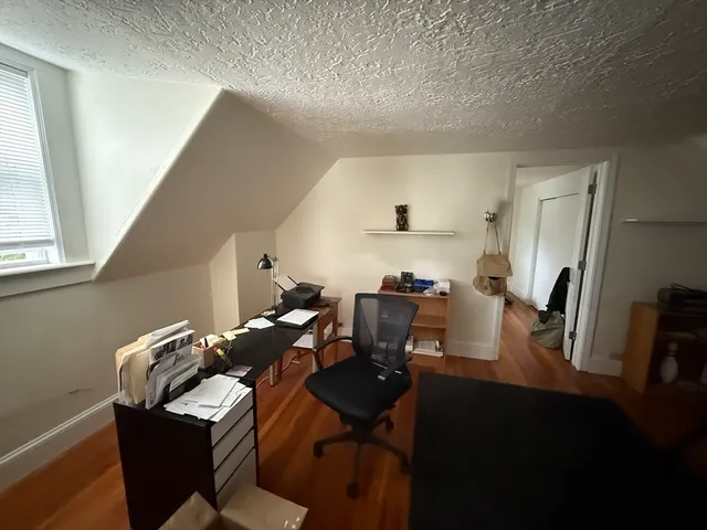 a view of a workspace with furniture and a window