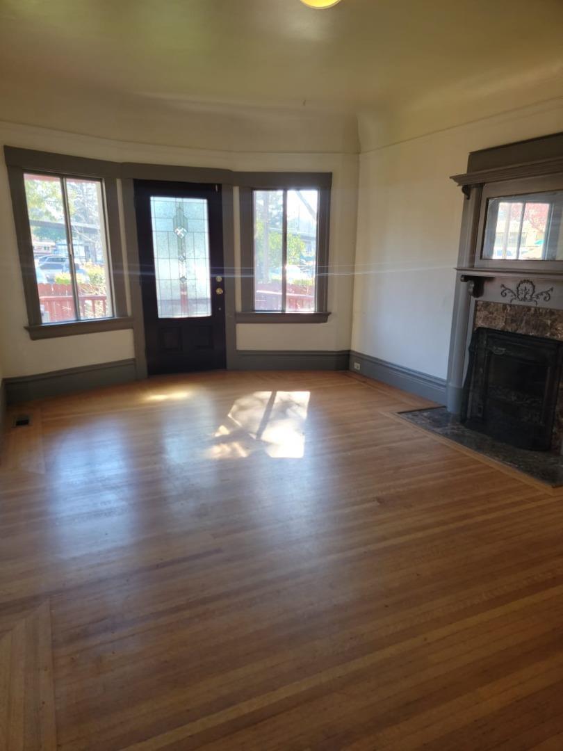 1921 Dwight Way Berkeley, CA 94704 - Photo 2 of 3 an empty room with wooden floor and windows