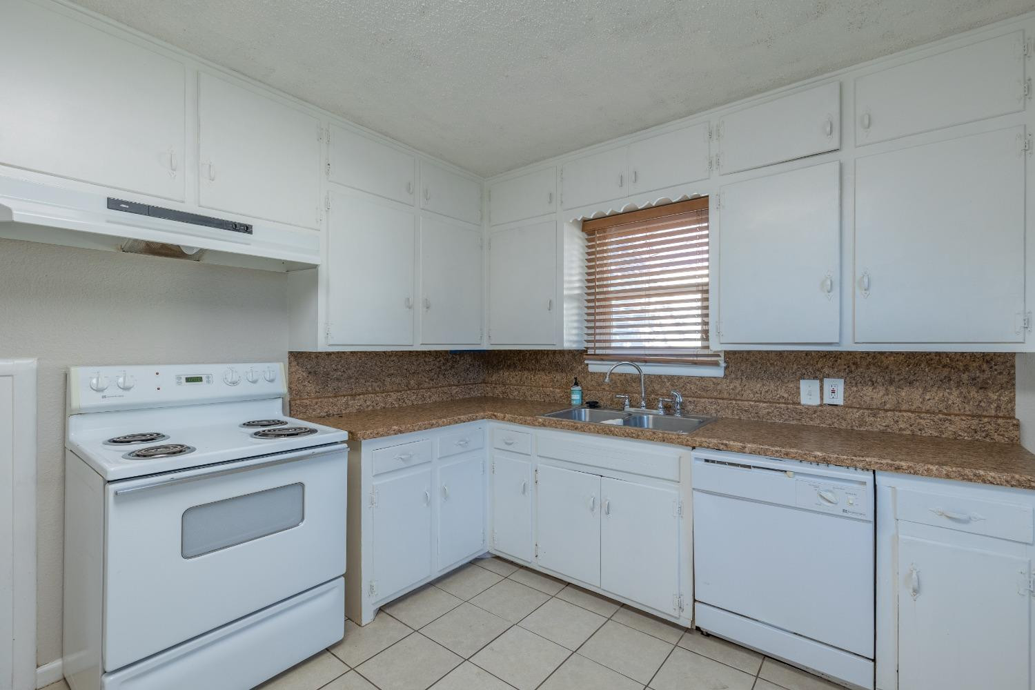 516 7th Street Wolfforth, TX 79382 - Photo 15 of 19 a kitchen with white cabinets appliances a sink and a window