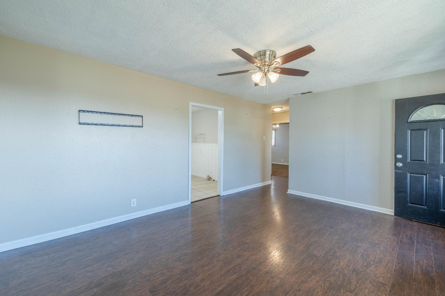 516 7th Street Wolfforth, TX 79382 - Photo 3 of 19 a view of an empty room with window and wooden floor