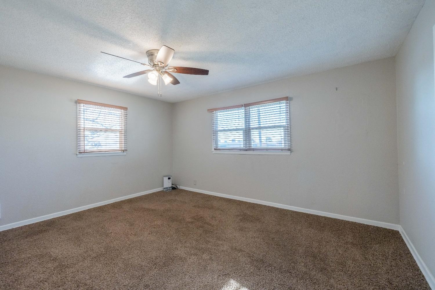516 7th Street Wolfforth, TX 79382 - Photo 4 of 19 an empty room with windows and fan