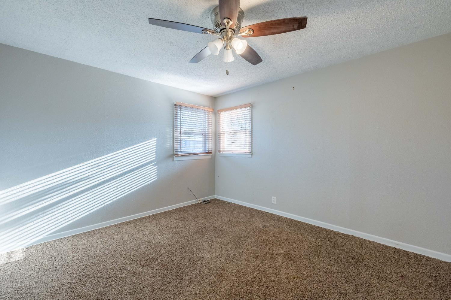 516 7th Street Wolfforth, TX 79382 - Photo 6 of 19 an empty room with windows and ceiling fan