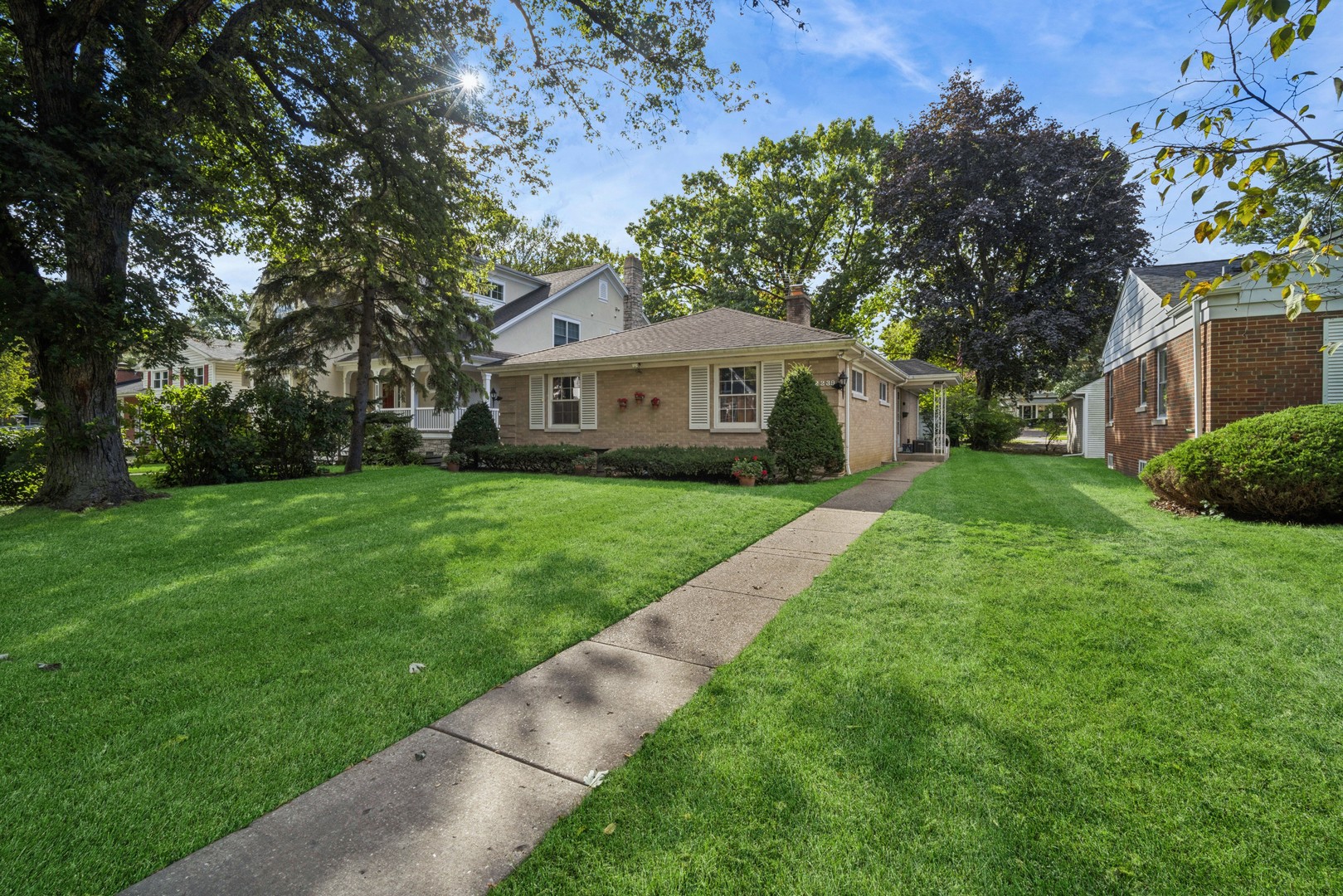a view of a house with a big yard and large tree
