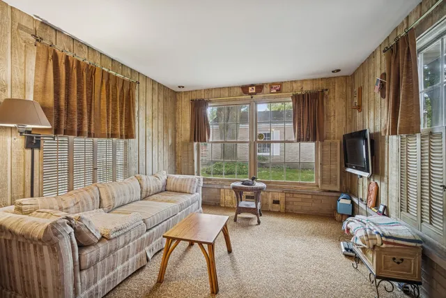 a living room with furniture a flat screen tv and a large window