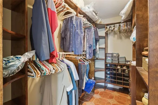 a view of walk in closet with clothes and shoes