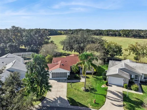 an aerial view of a house with green landscape and city view