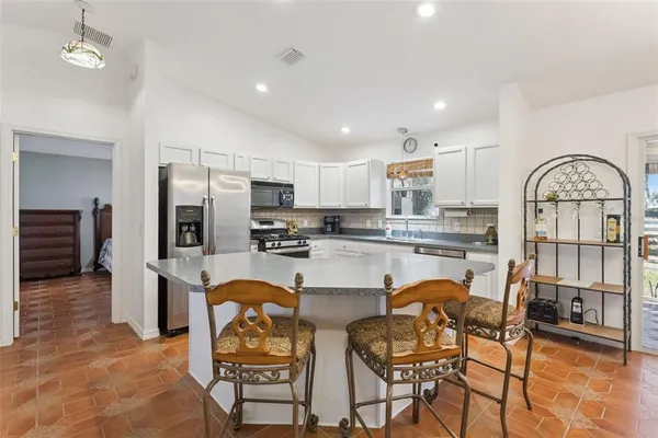 a kitchen with stainless steel appliances granite countertop a refrigerator and microwave