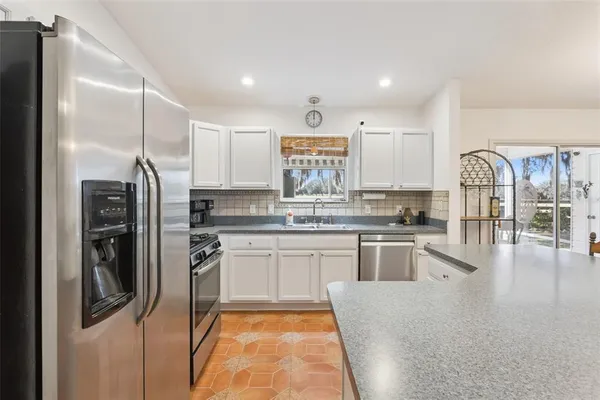 a kitchen with stainless steel appliances granite countertop a refrigerator sink and stove