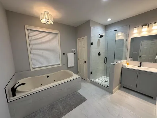 a kitchen with stainless steel appliances a dining table chairs refrigerator and microwave