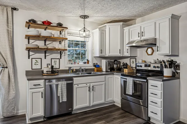 a kitchen with stainless steel appliances granite countertop a sink and cabinets
