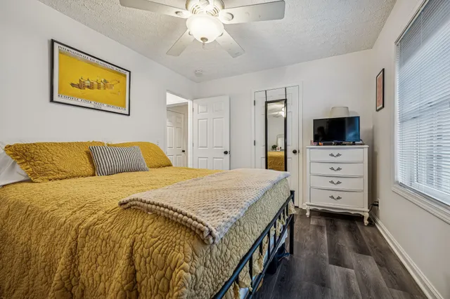 a bedroom with a bed and a flat tv screen on dresser