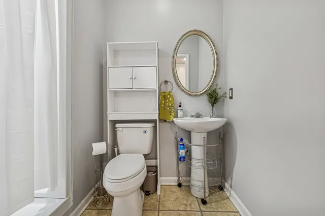 a bathroom with a toilet sink and a mirror
