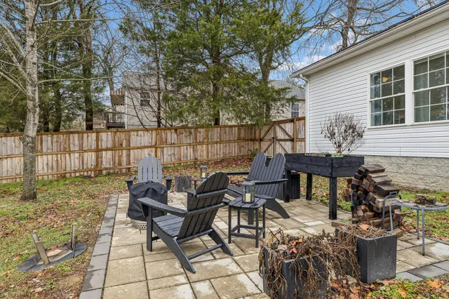 a view of a patio with table and chairs with wooden fence and plants