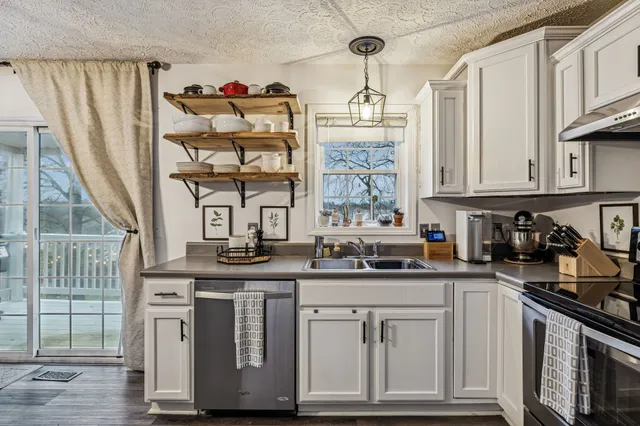 a kitchen with stainless steel appliances a sink stove and cabinets