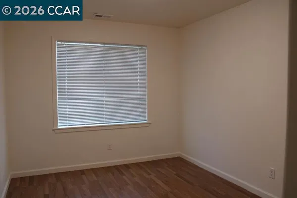 a view of a small space with wooden floor and a window