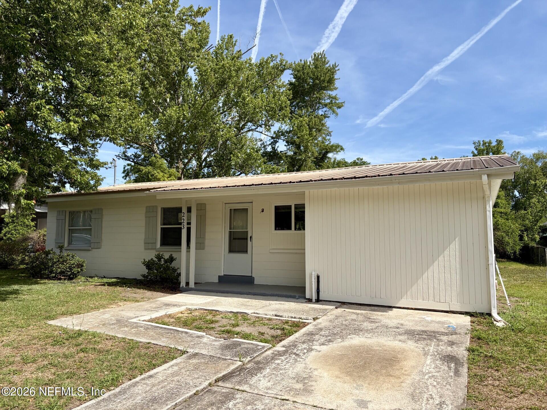 223 North Collen Road Jacksonville, FL 32218 - Photo 3 of 11 a view of a house with a backyard and a garage