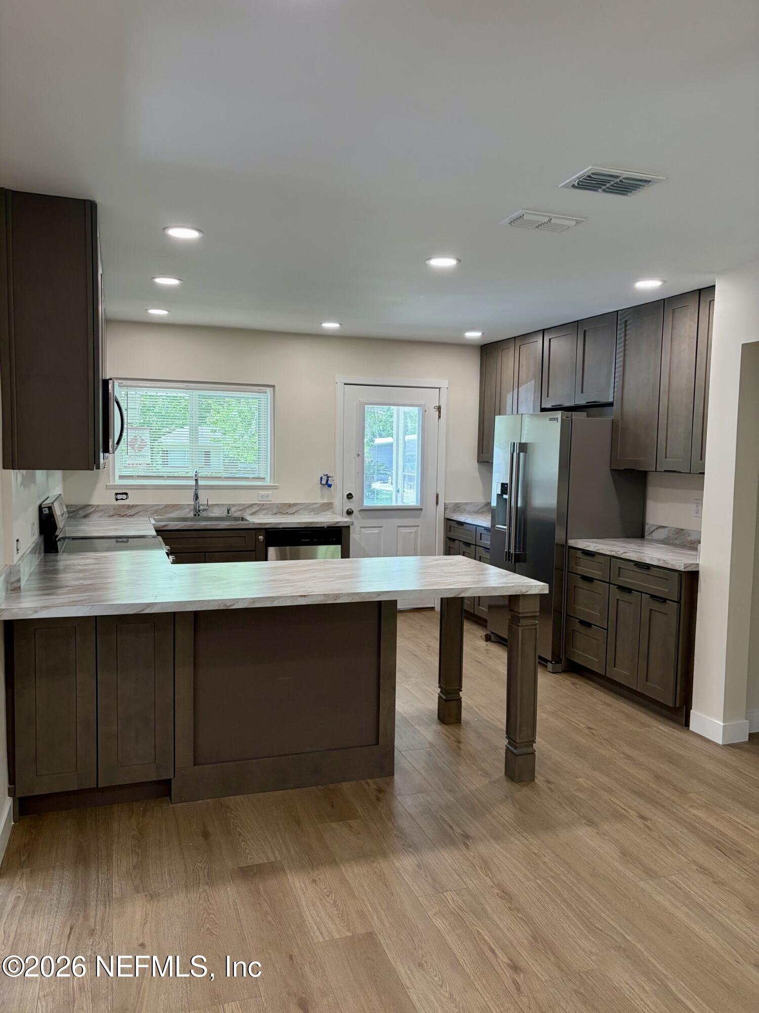 223 North Collen Road Jacksonville, FL 32218 - Photo 5 of 11 a kitchen with counter top space cabinets and appliances