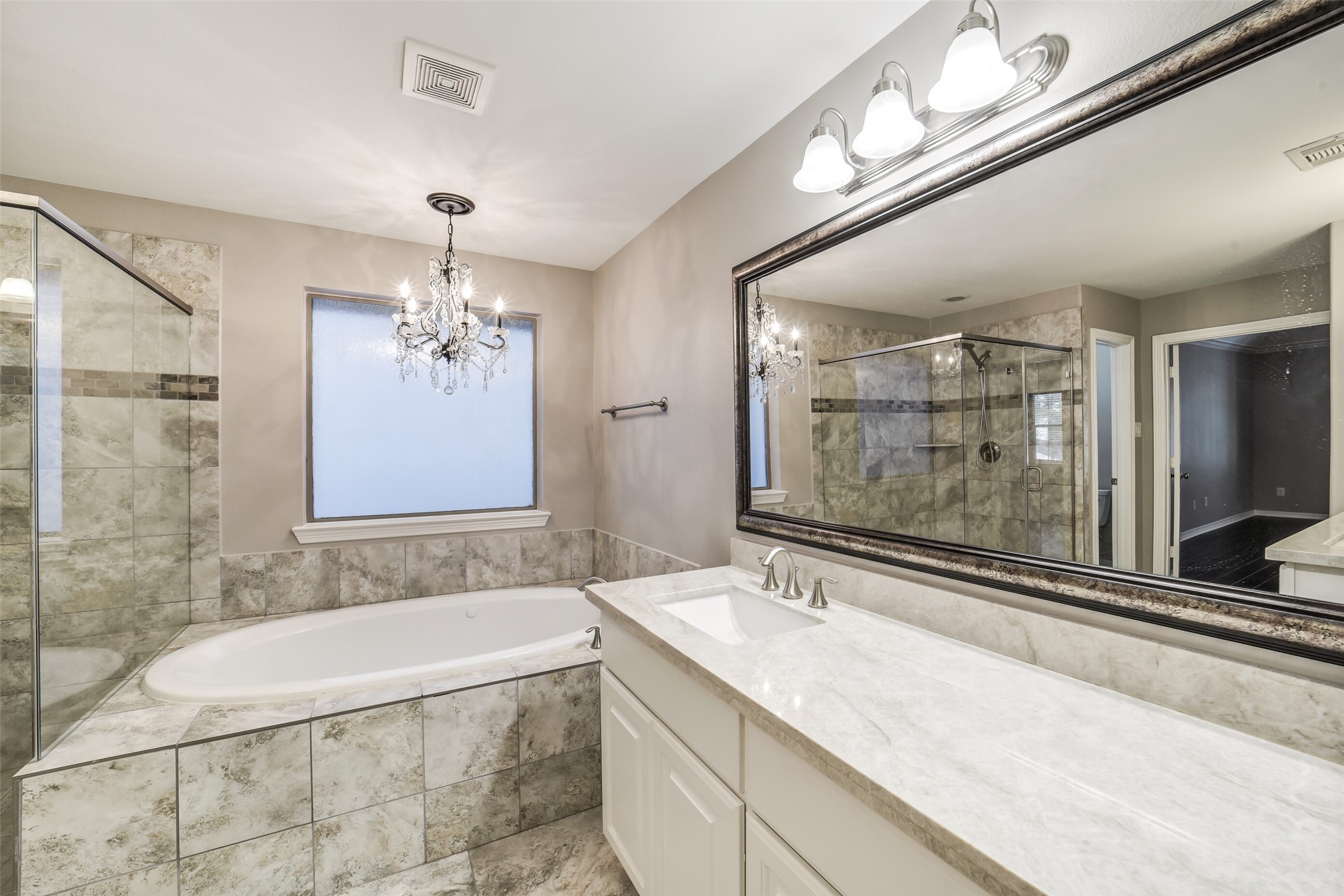 1303 Dorothy Street Houston, TX 77008 - Photo 11 of 21 Another large vanity with storage. Large soaking tub with decorative light fixture above. Separate walk in shower.