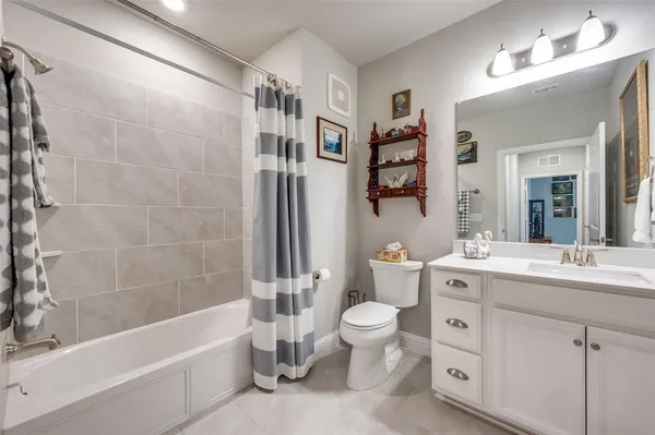 a bathroom with a bathtub shower sink mirror vanity and toilet