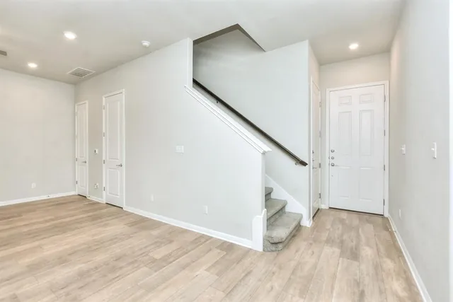 a view of hallway with stairs and wooden floor